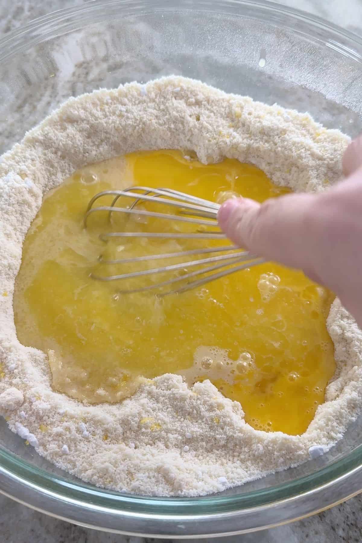 Mixing the wet ingredients with the dry ingredients.