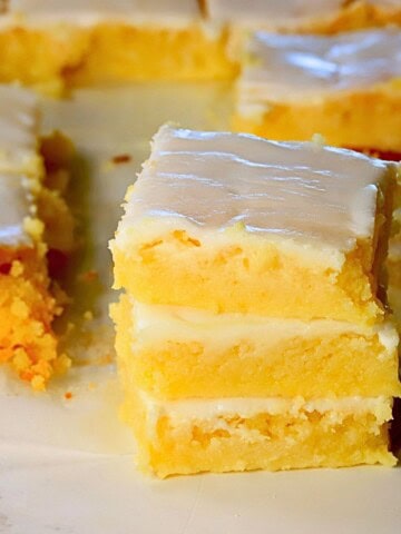 Three low carb lemon brownies stacked on top of each other.