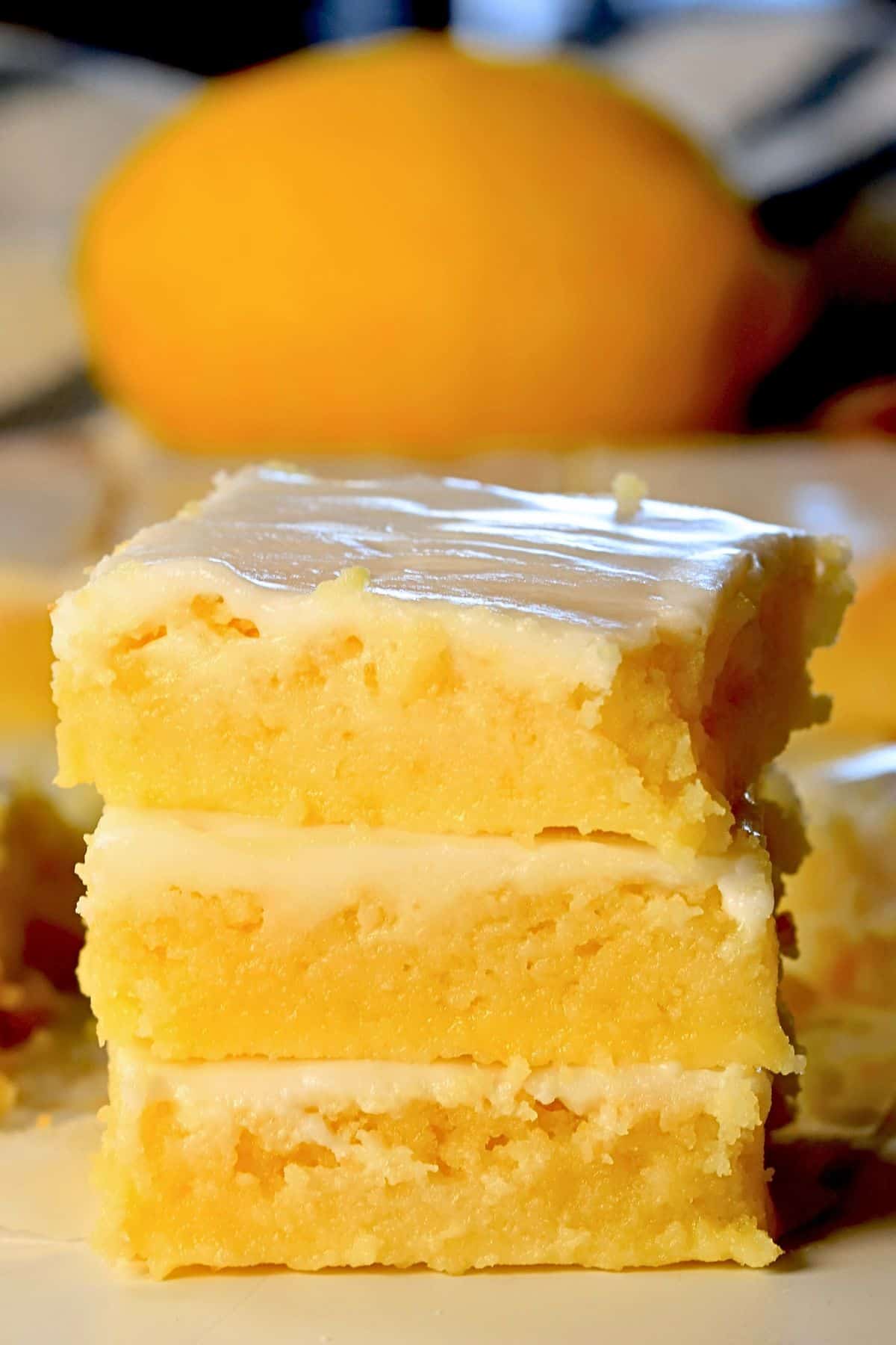 Three low carb lemon brownies stacked on top of each other.