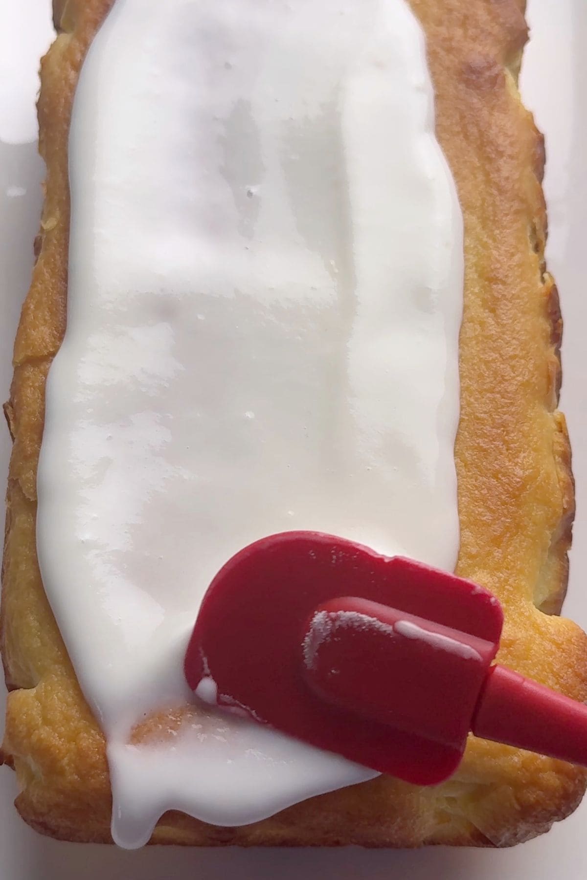 Spreading the lemon glaze on the cake.