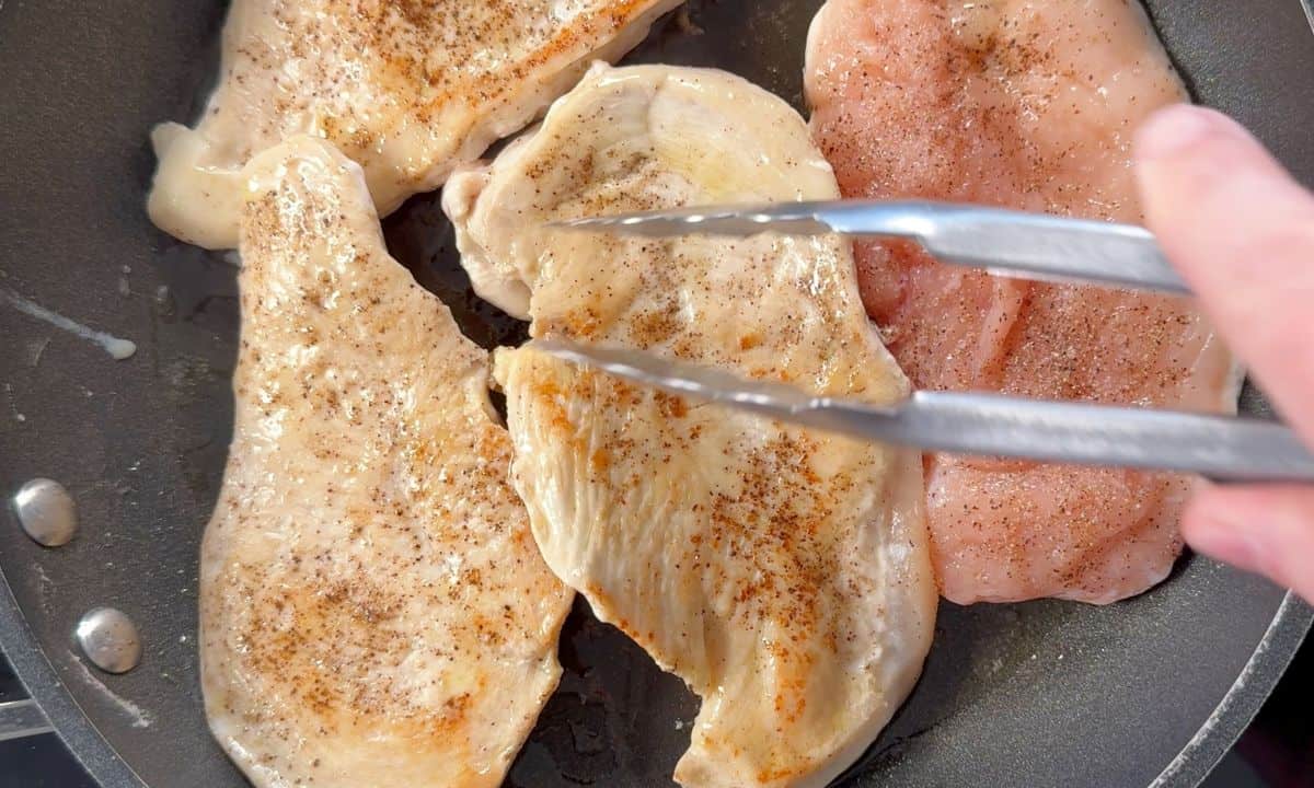 Browning the chicken in a frying pan.