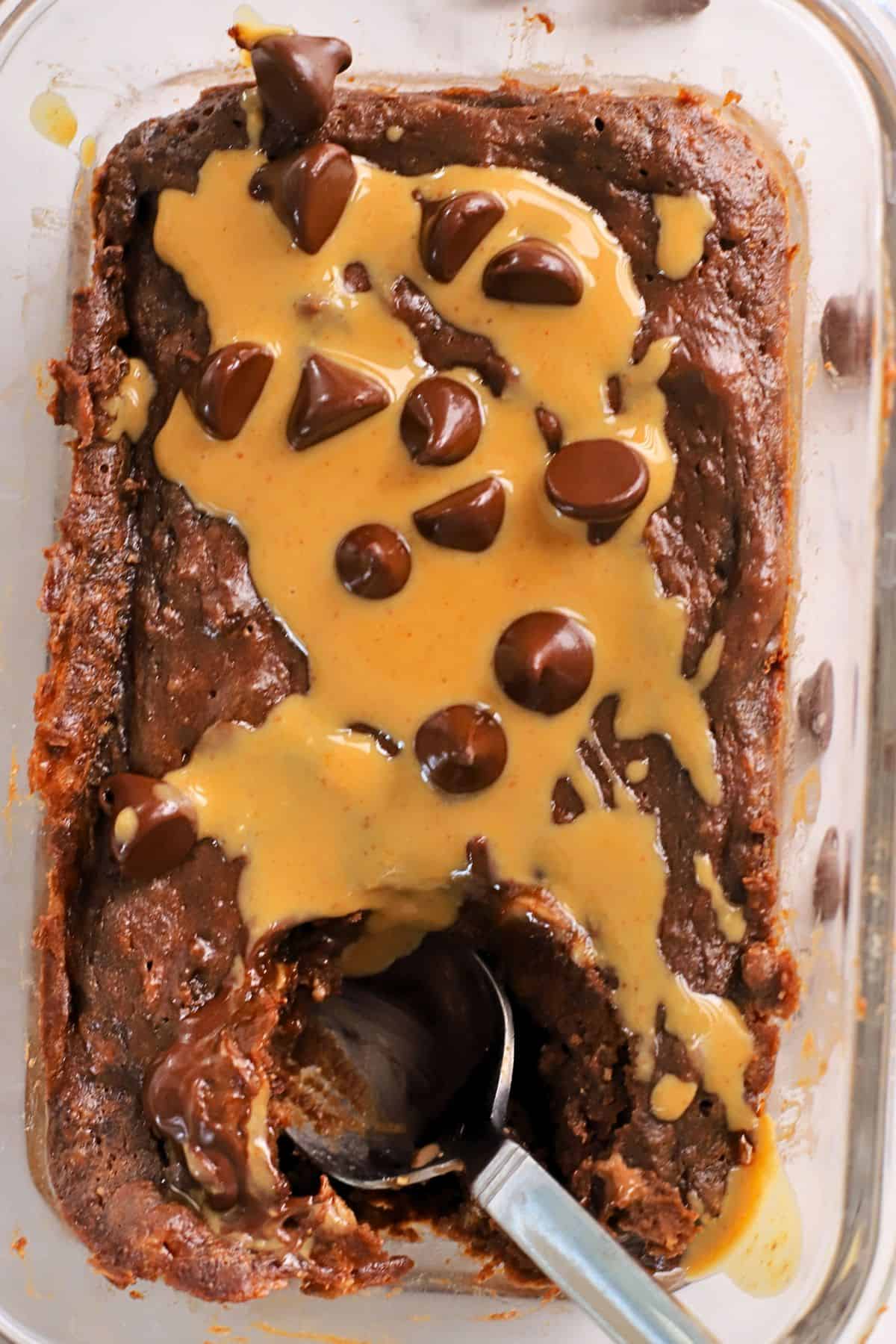 Cottage cheese chocolate protein mug cake drizzled with peanut butter and topped with chocolate chips.