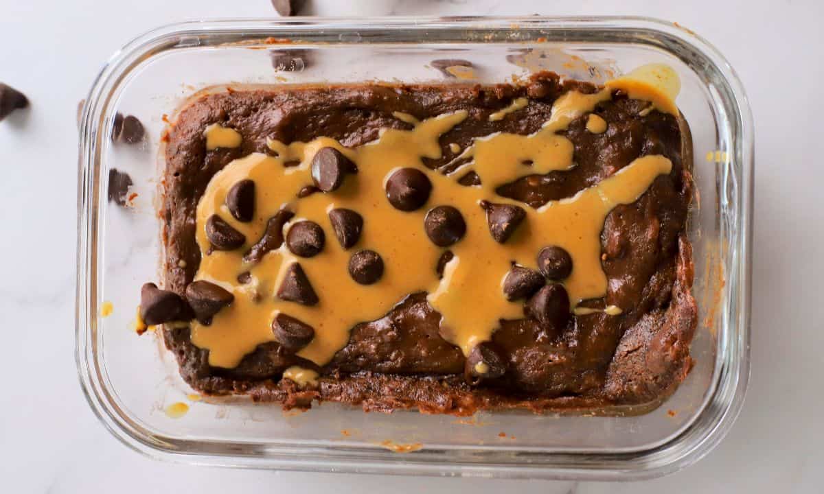 Cottage cheese chocolate protein mug cake drizzled with peanut butter and topped with chocolate chips.