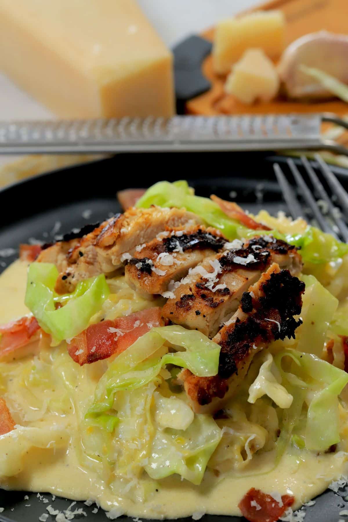 Low carb cabbage alfredo with chicken and bacon on a plate.