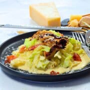 Low carb cabbage alfredo with chicken and bacon on a plate.