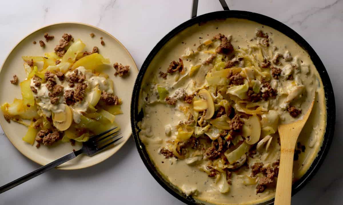 Low carb cabbage beef stroganoff in a skillet and on a plate.