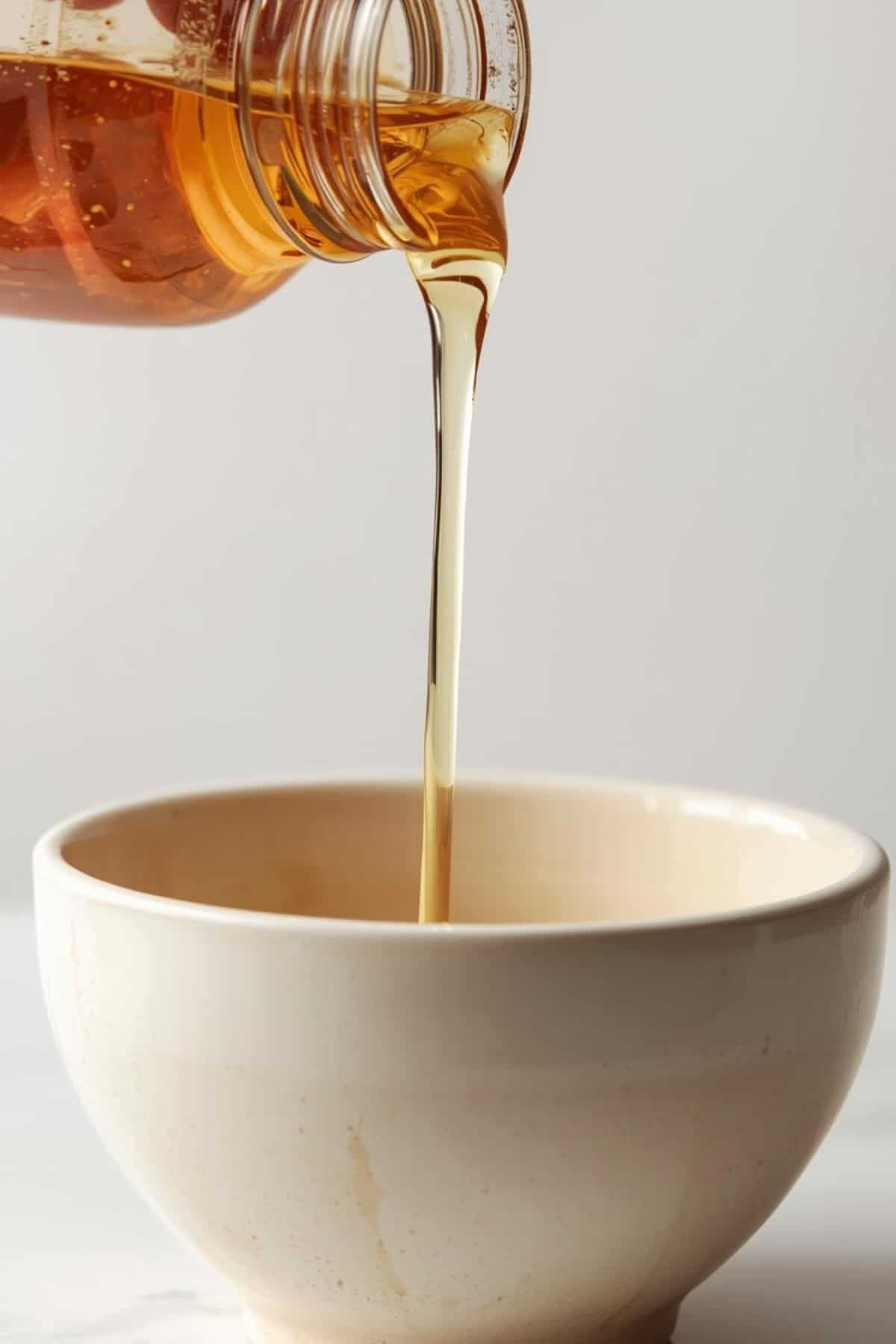Pouring low carb simple syrup from a jar into a bowl.