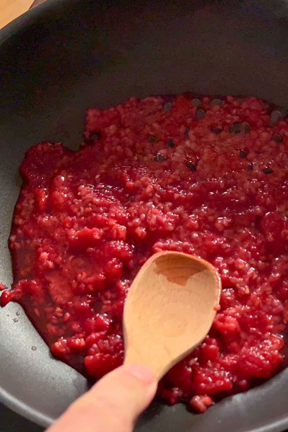 Cooking the raspberries in a pan.