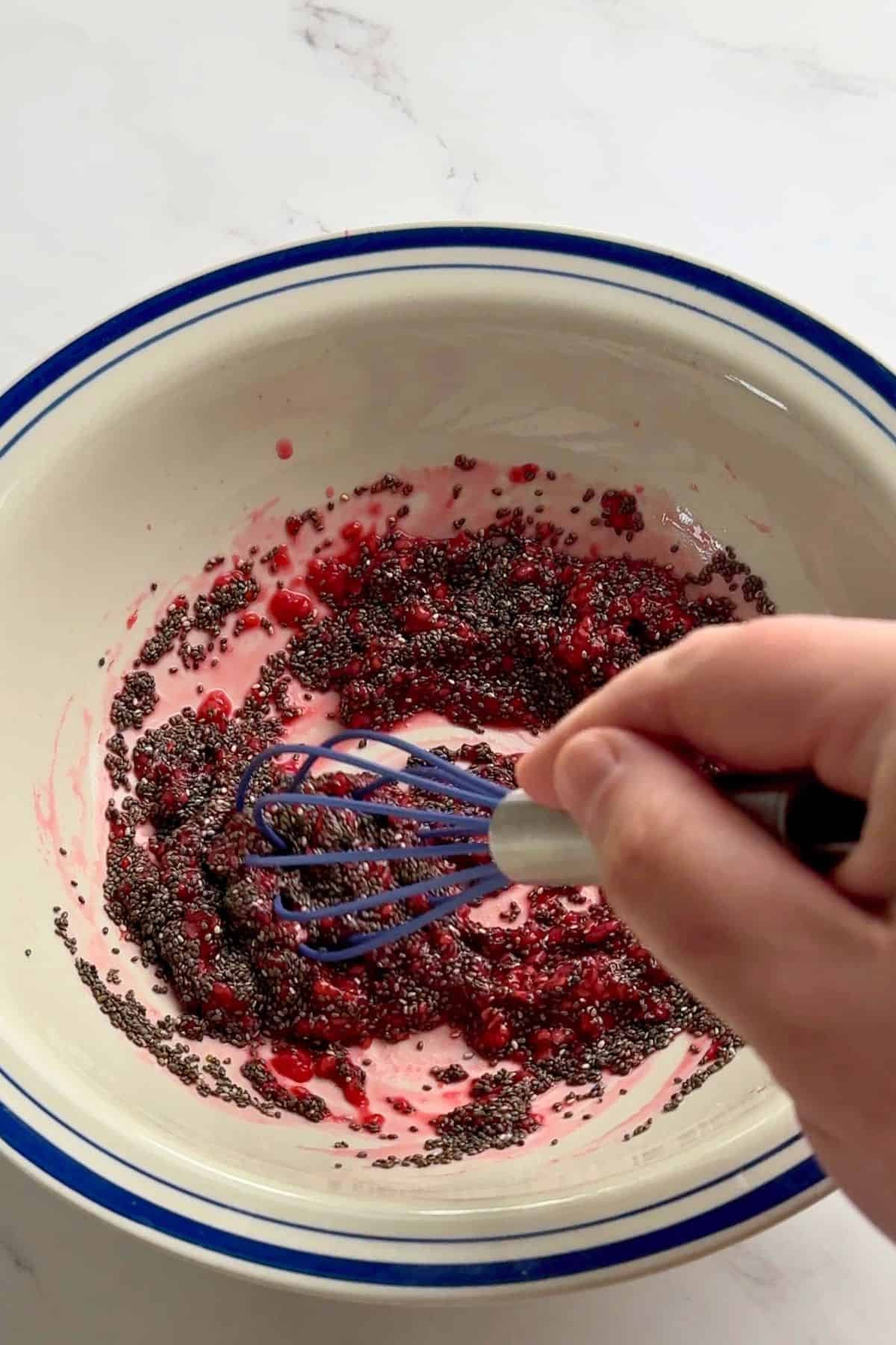 Whisking together the chia seeds and raspberry jam.