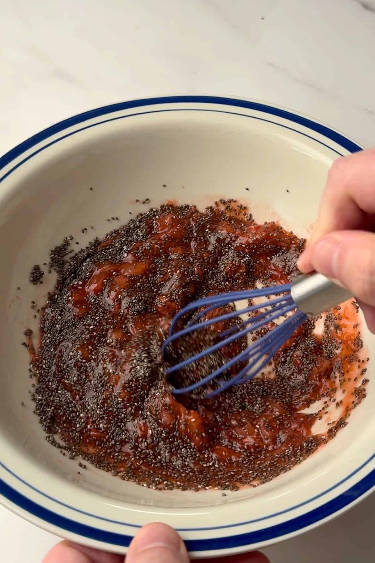Whisking the chia seeds with the cooked strawberries.