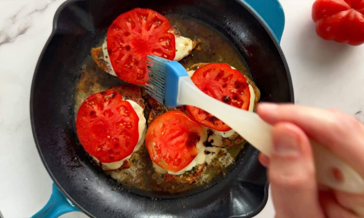 Drizzling the balsamic over the tomatoes.