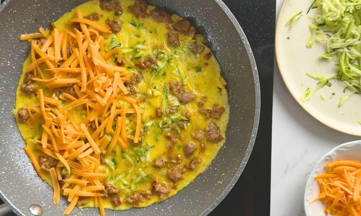 Omelette with shredded cheddar on top.