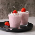 Two cups of low carb strawberry coconut chia pudding topped with strawberries.