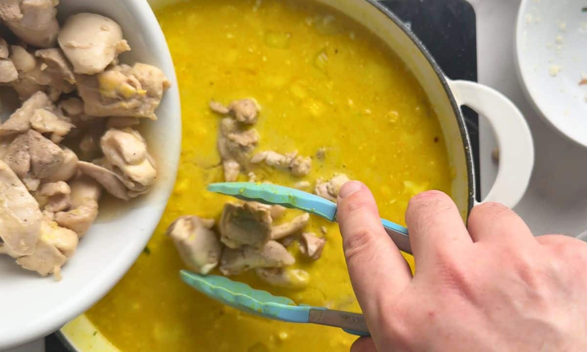Adding the chicken to the sauce in the skillet.