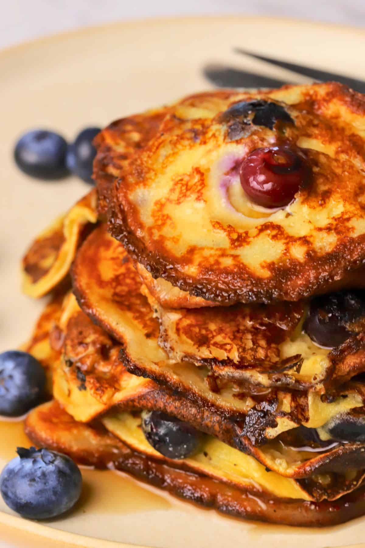 Blueberry cottage cheese pancakes served on a plate with fresh blueberries.