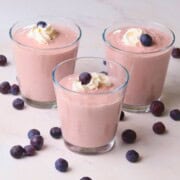 Low carb blueberry cottage cheese pudding in cups topped with whipped cream and blueberries.