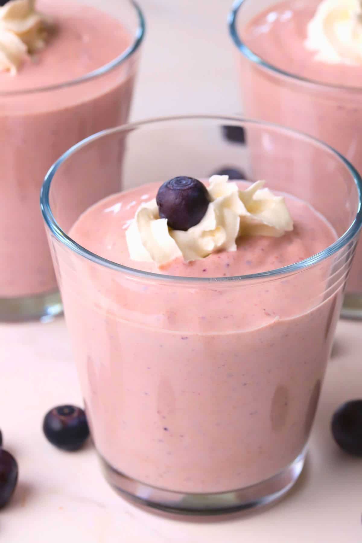 Low carb blueberry cottage cheese pudding in cups topped with whipped cream and blueberries.