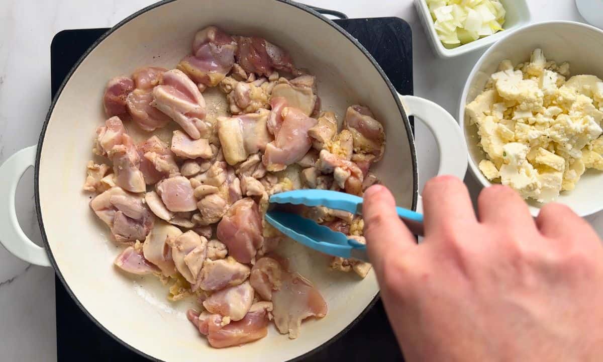 Browning the chicken in the skillet.