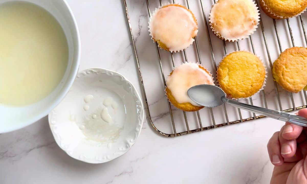 Spooning the glaze over the muffins.