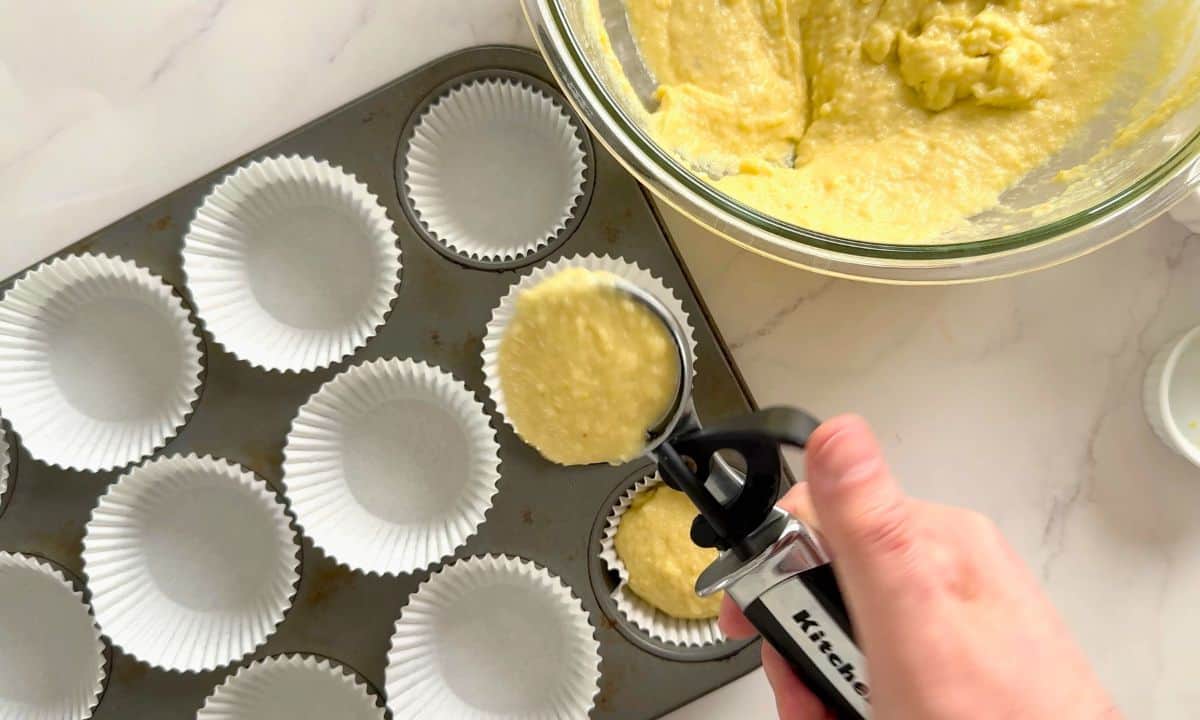 Scooping the batter into the muffin liners.