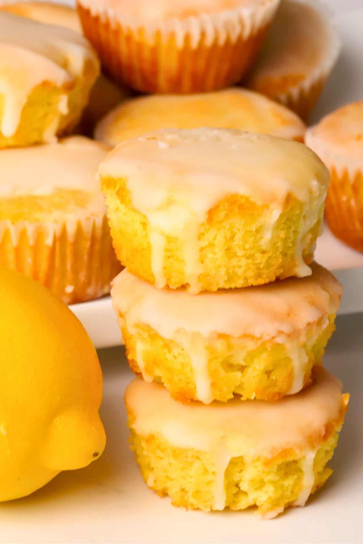 Sugar free lemon muffins stacked on top of each other next to a lemon.