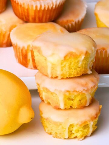 Sugar free lemon muffins stacked on top of each other next to a lemon.