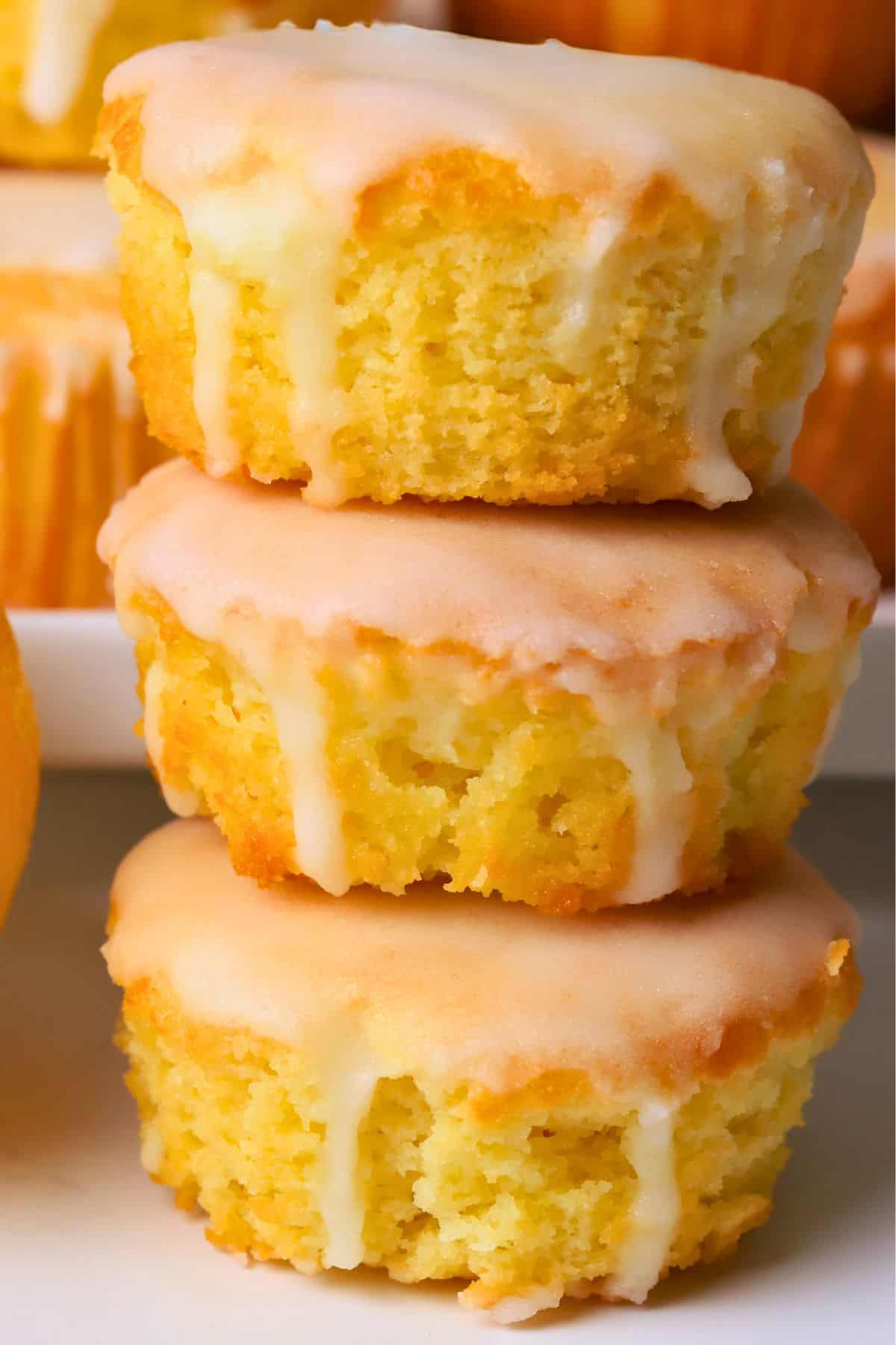 Sugar free lemon muffins stacked on top of each other next to a lemon.