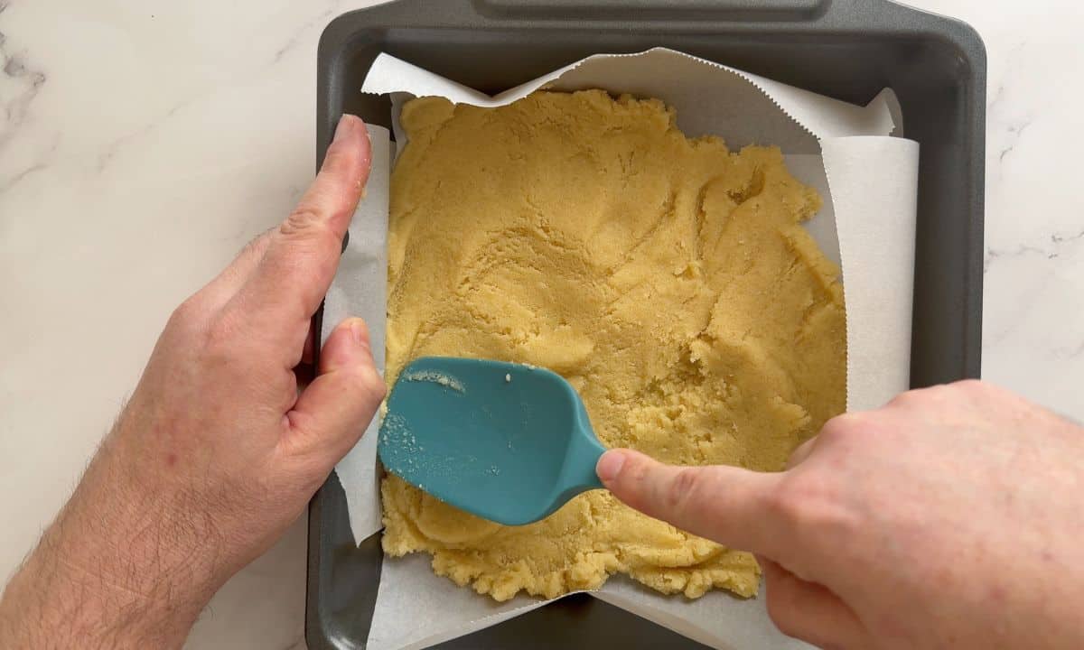 Spreading the crust on to the parchment lined baking pan.