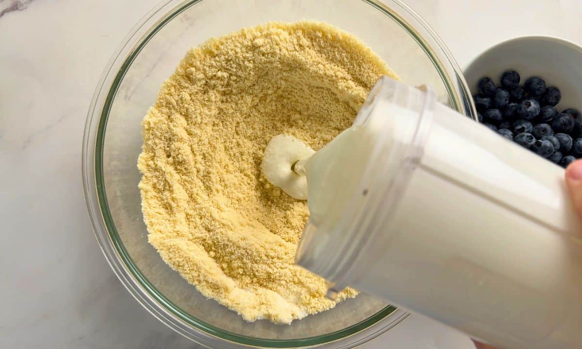 Pouring the blended cottage cheese into the dry ingredients.