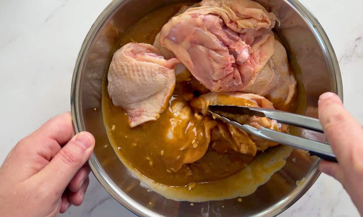 Mixing the chicken in the marinade.