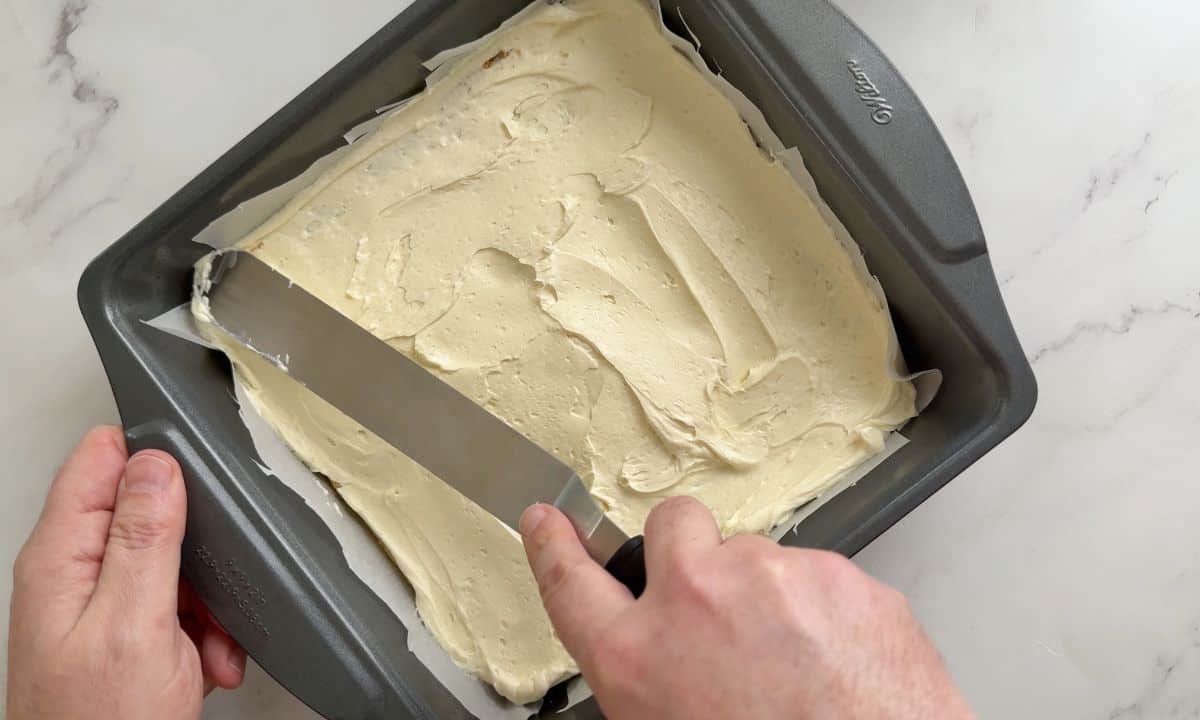 Spreading the cream cheese layer on to the crust.