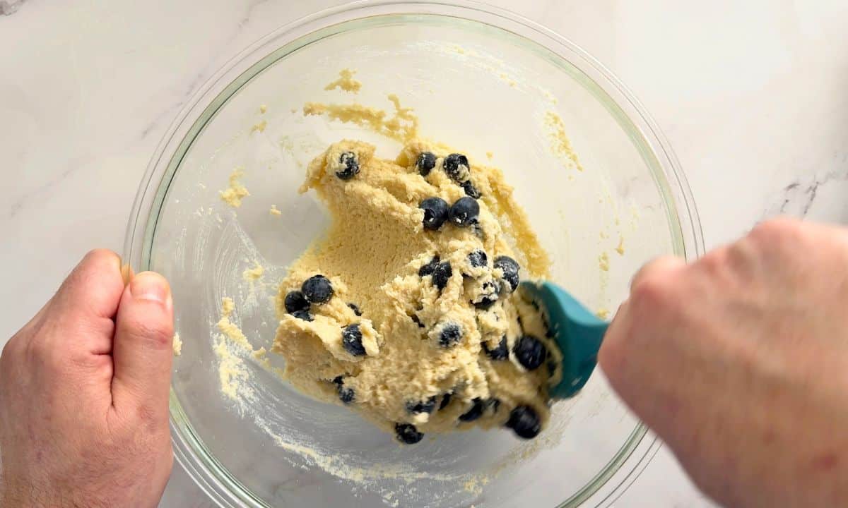 Folding in the blueberries into the batter.
