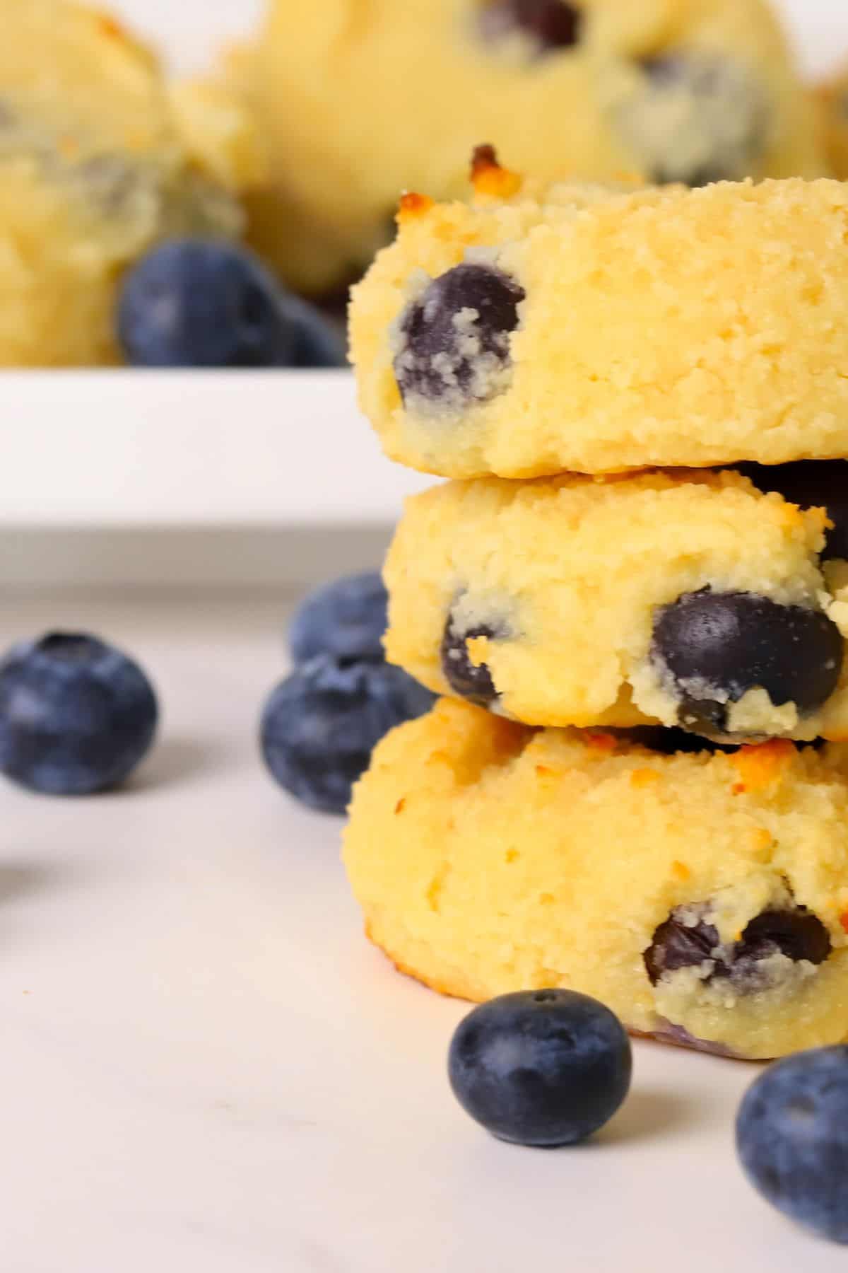 Three low carb blueberry cottage cheese cookies stacked on top of each other.