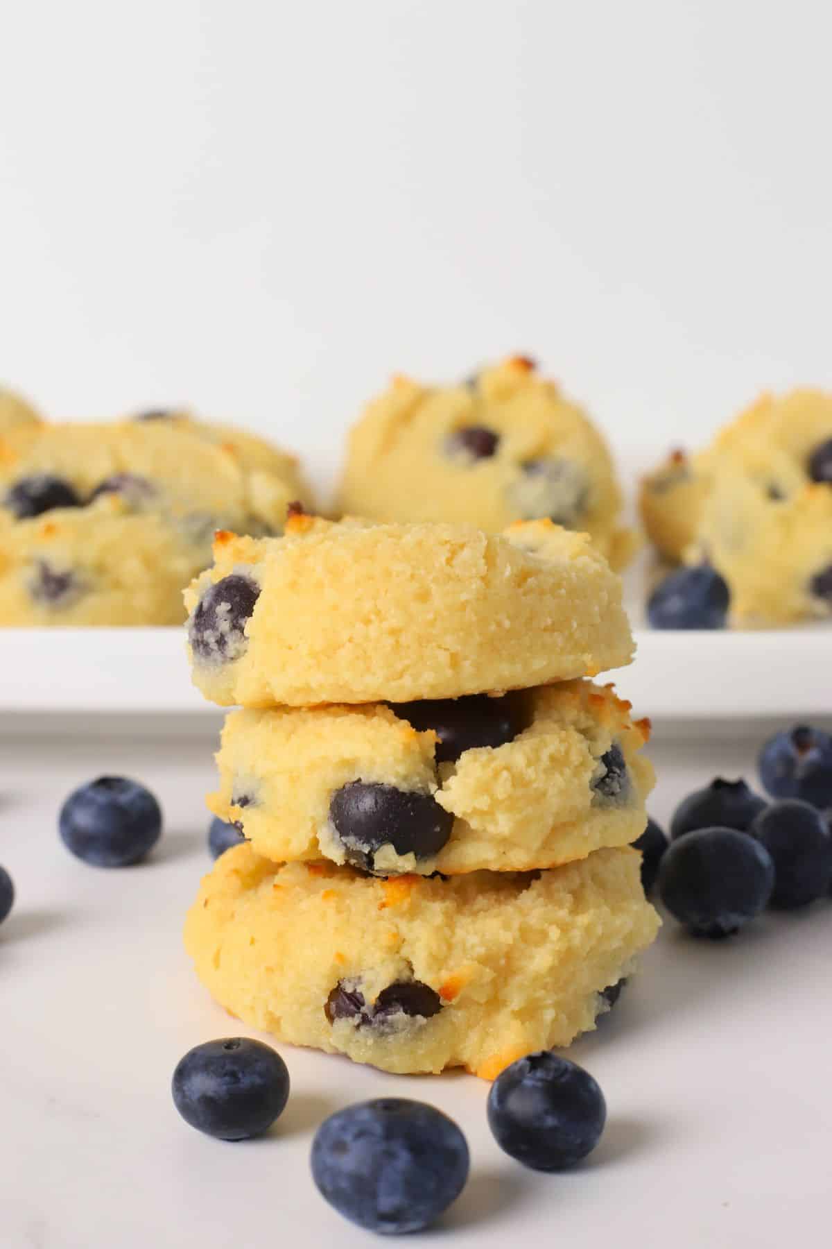 Three low carb blueberry cottage cheese cookies stacked on top of each other.