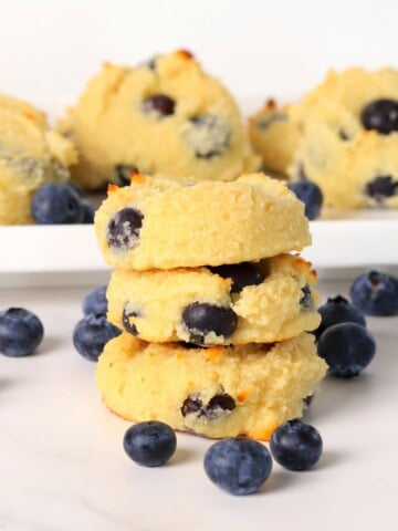 Three low carb blueberry cottage cheese cookies stacked on top of each other.