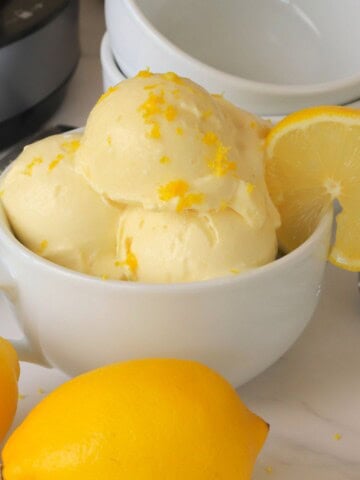 Low carb lemon ice cream in a bowl with a lemon slice.