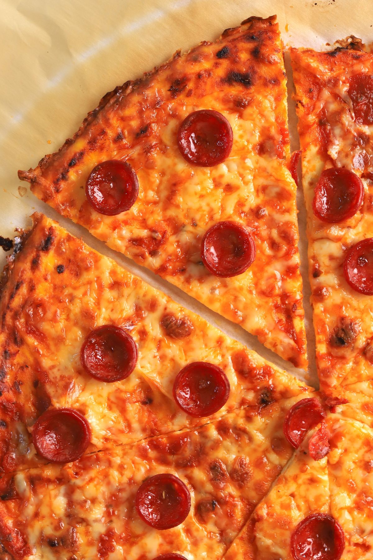 A slice of low carb pizza crust on a parchment sheet.