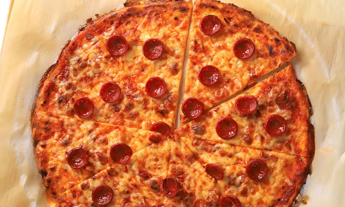 Low carb pizza crust on a parchment sheet.