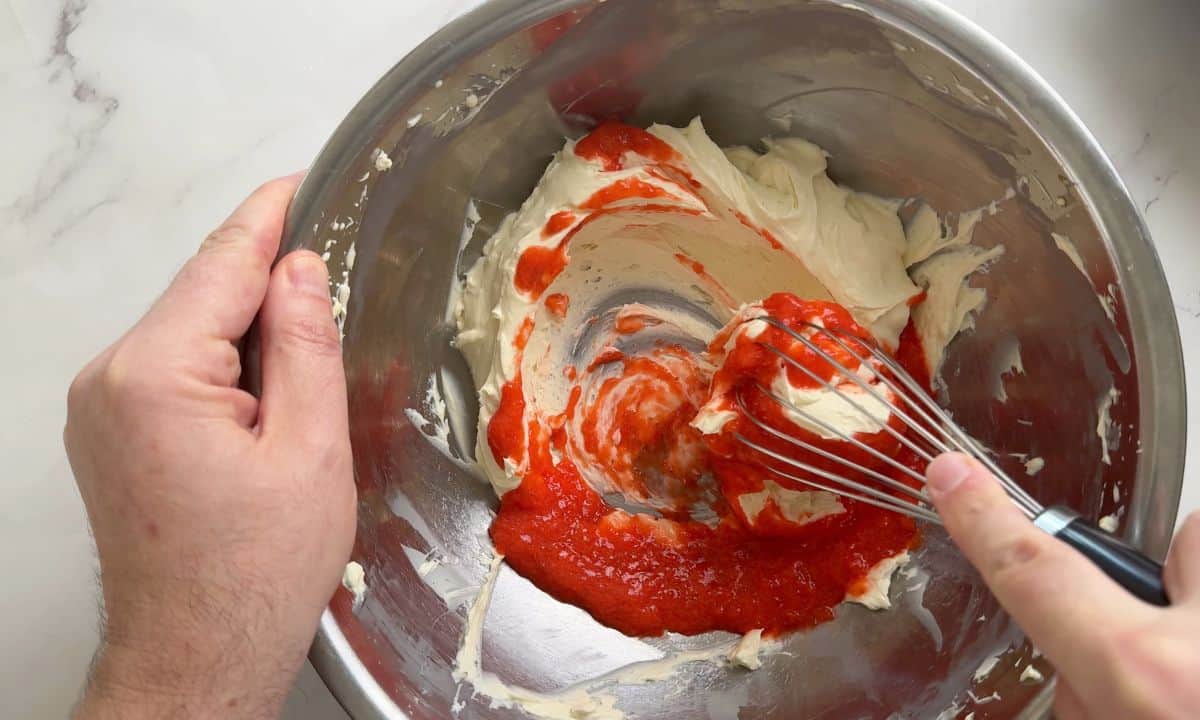 Mixing the strawberry puree with the cream cheese.
