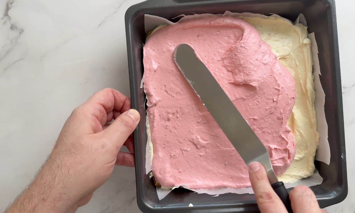 Spreading the strawberry cream cheese mixture on to the cream cheese layer.