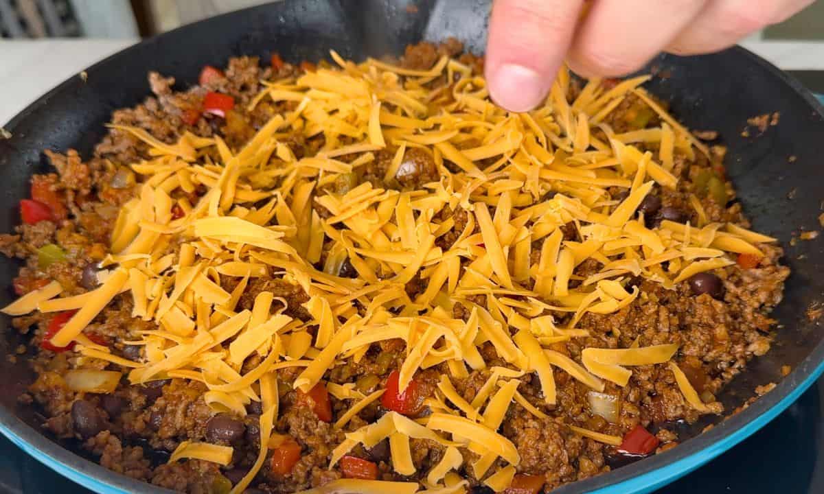 Topped the meat with shredded cheese.