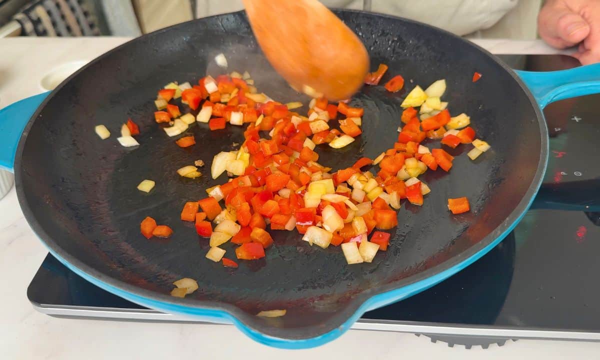 Sauteeing the onions and red pepper in the skillet.