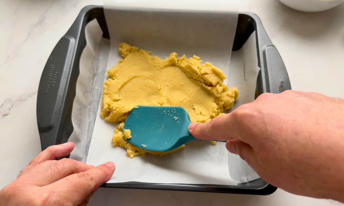 Spreading the crust into the pan.
