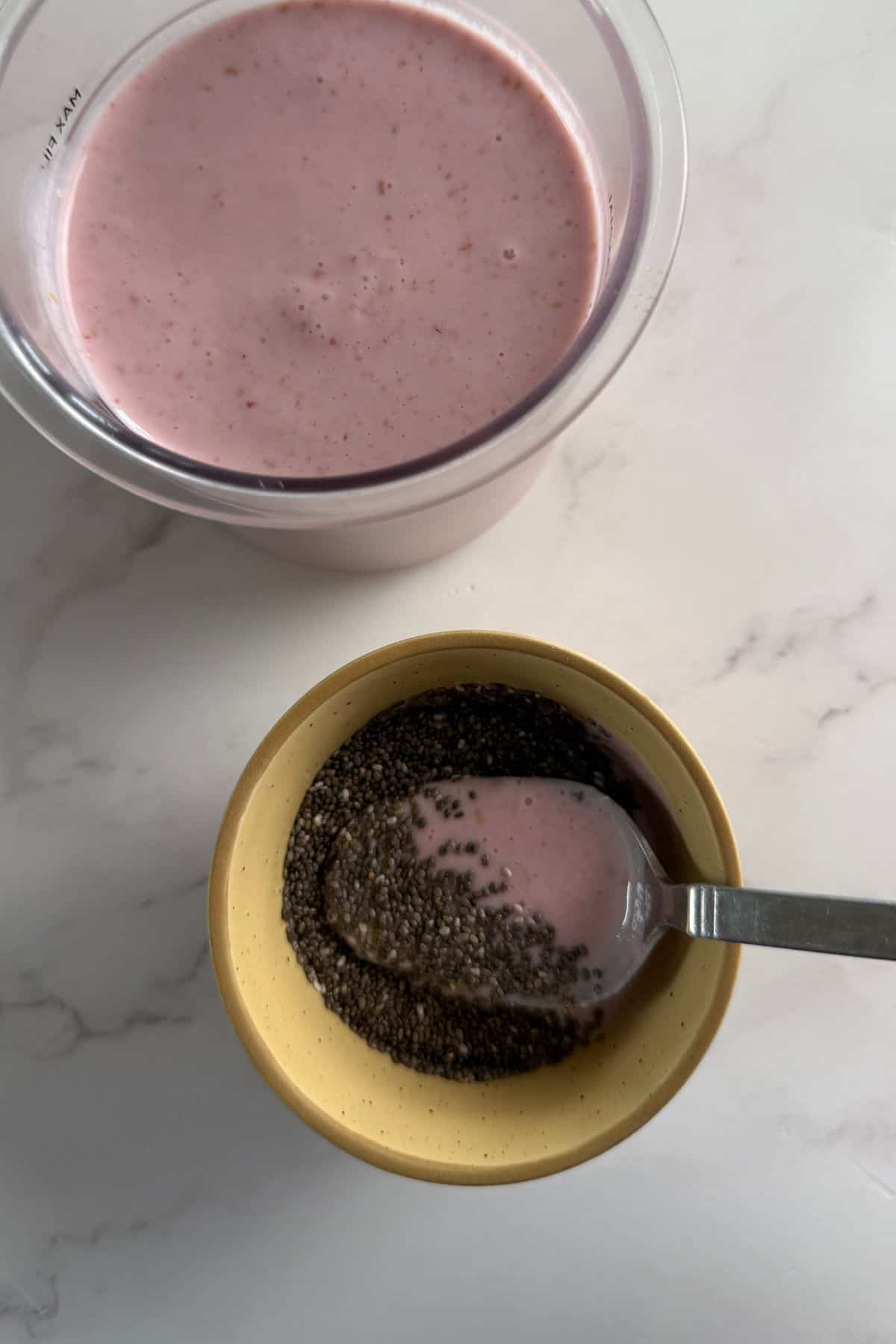 Blended ingredients in the ninja creami pint next to a bowl with chia seeds and some of the blended mixture.