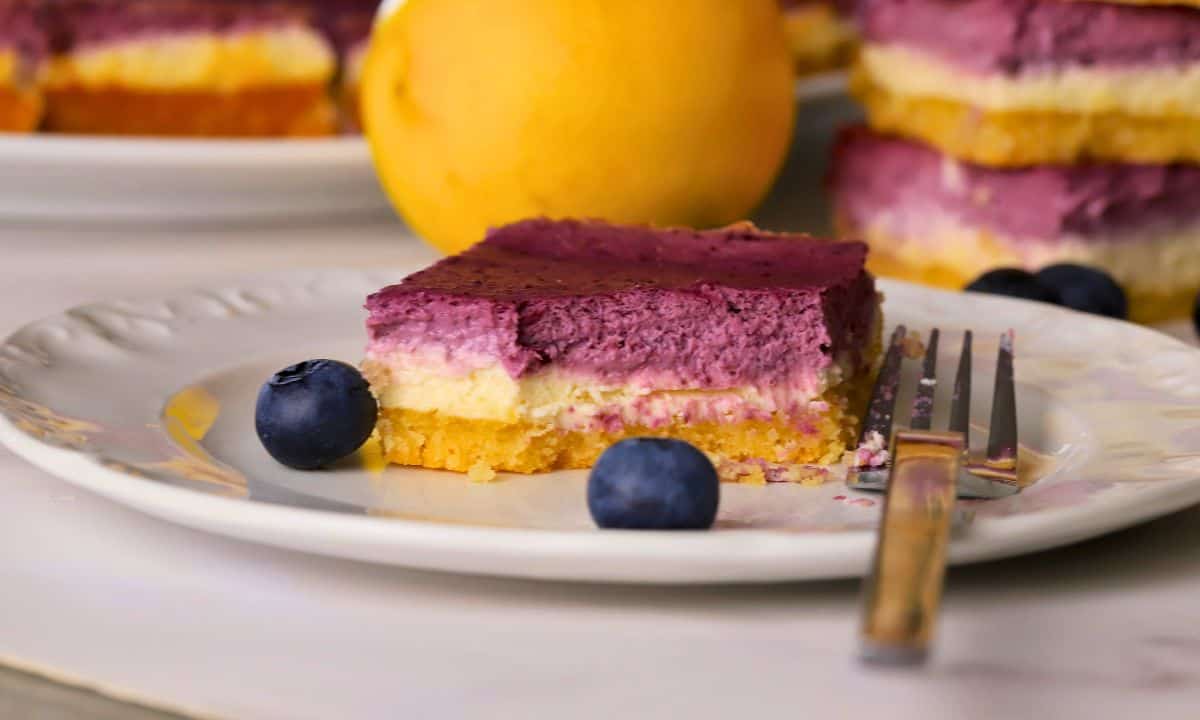 Low carb lemon blueberry cheesecake bar on a plate with a fork.