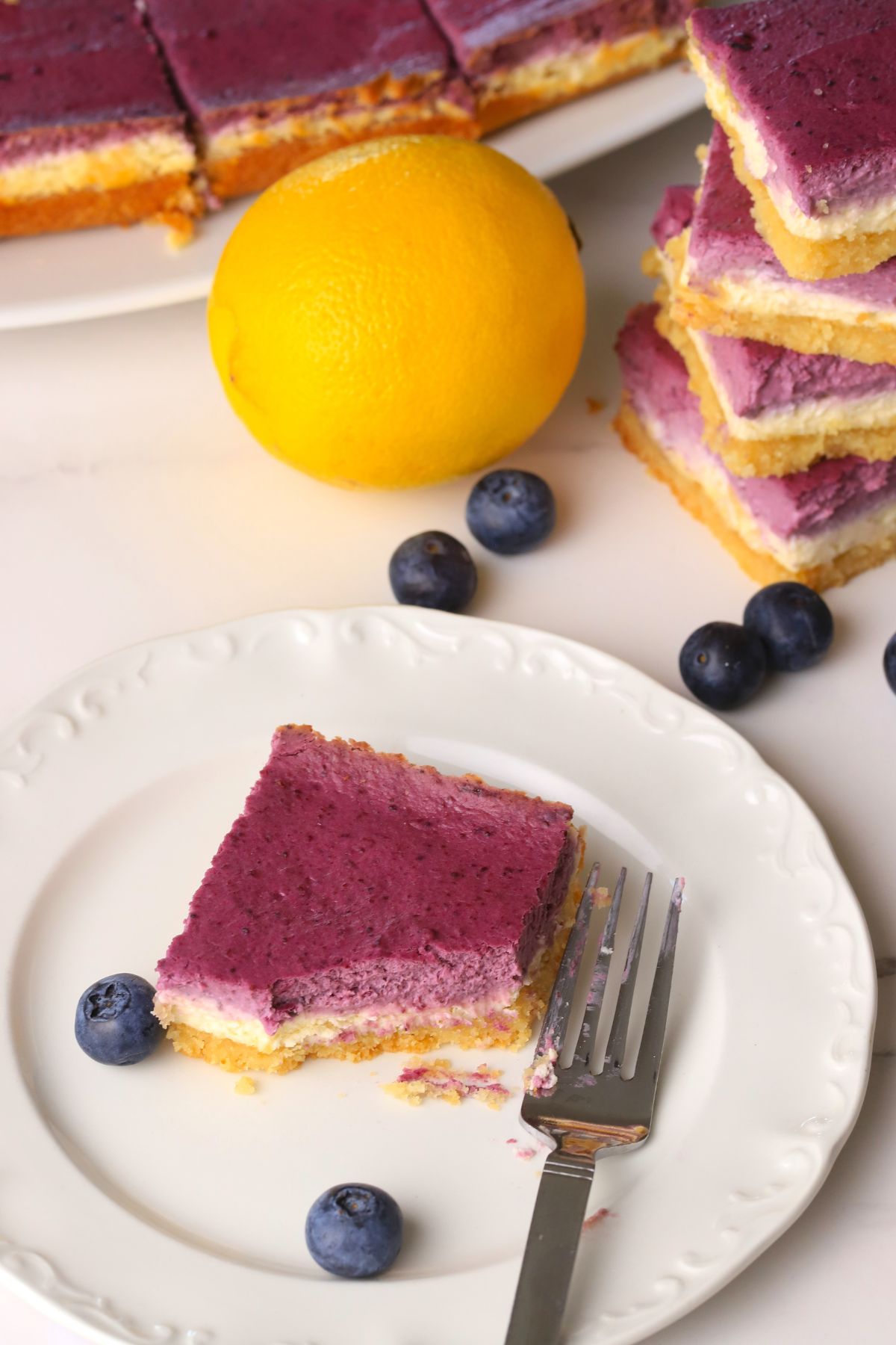 Low carb lemon blueberry cheesecake bar slice on a place with a fork.