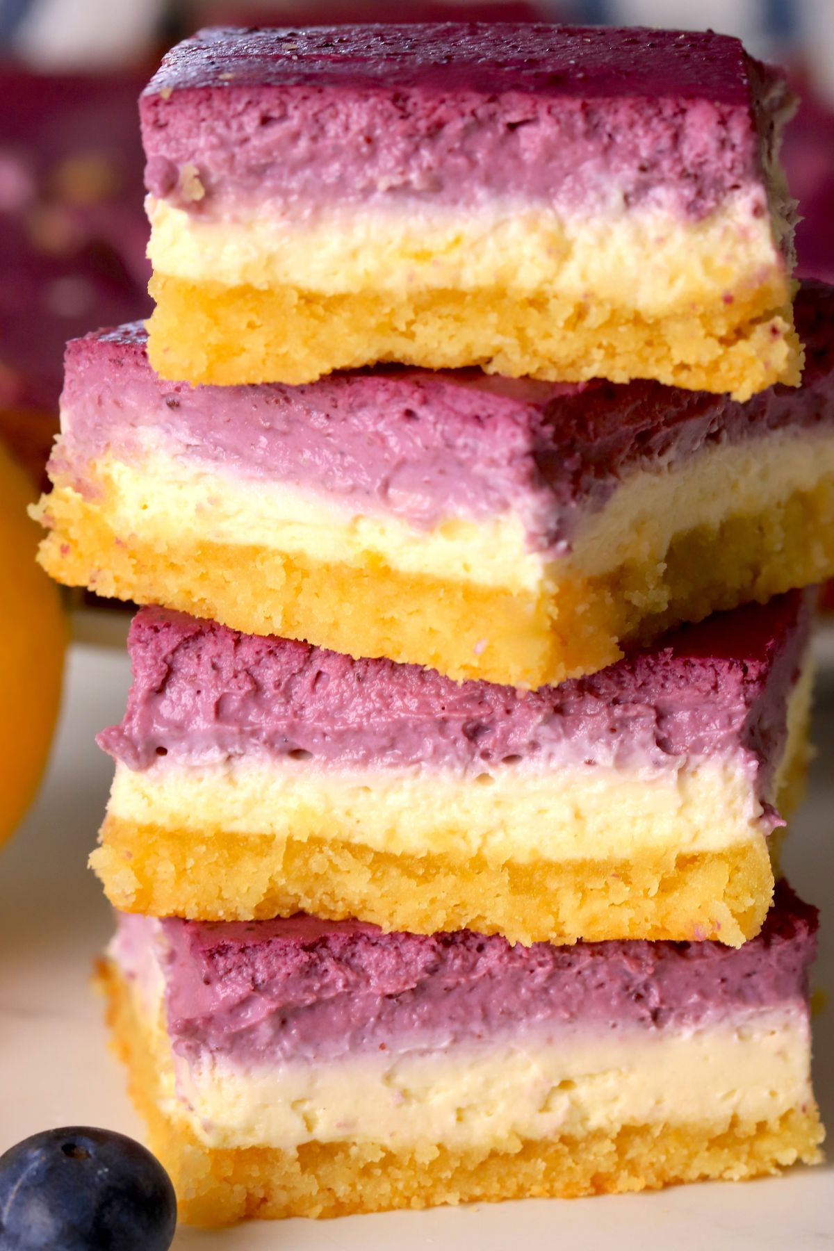 Low carb lemon blueberry cheesecake bars stacked on top of each other.