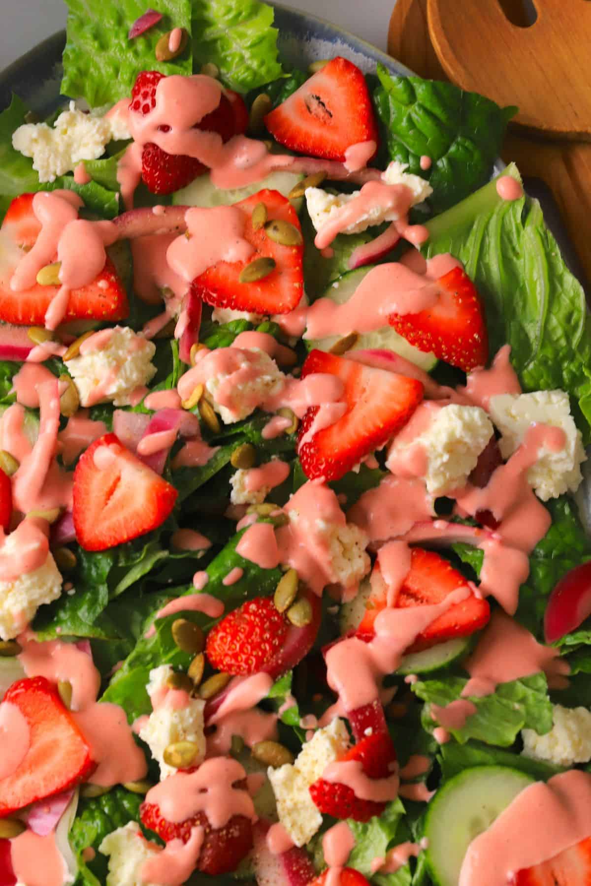 Low carb strawberry feta salad with strawberry dressing on a platter.
