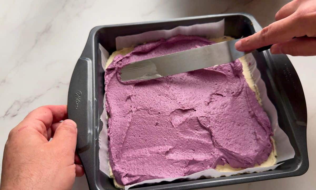 Layering the blueberry cream cheese layer onto the cake.