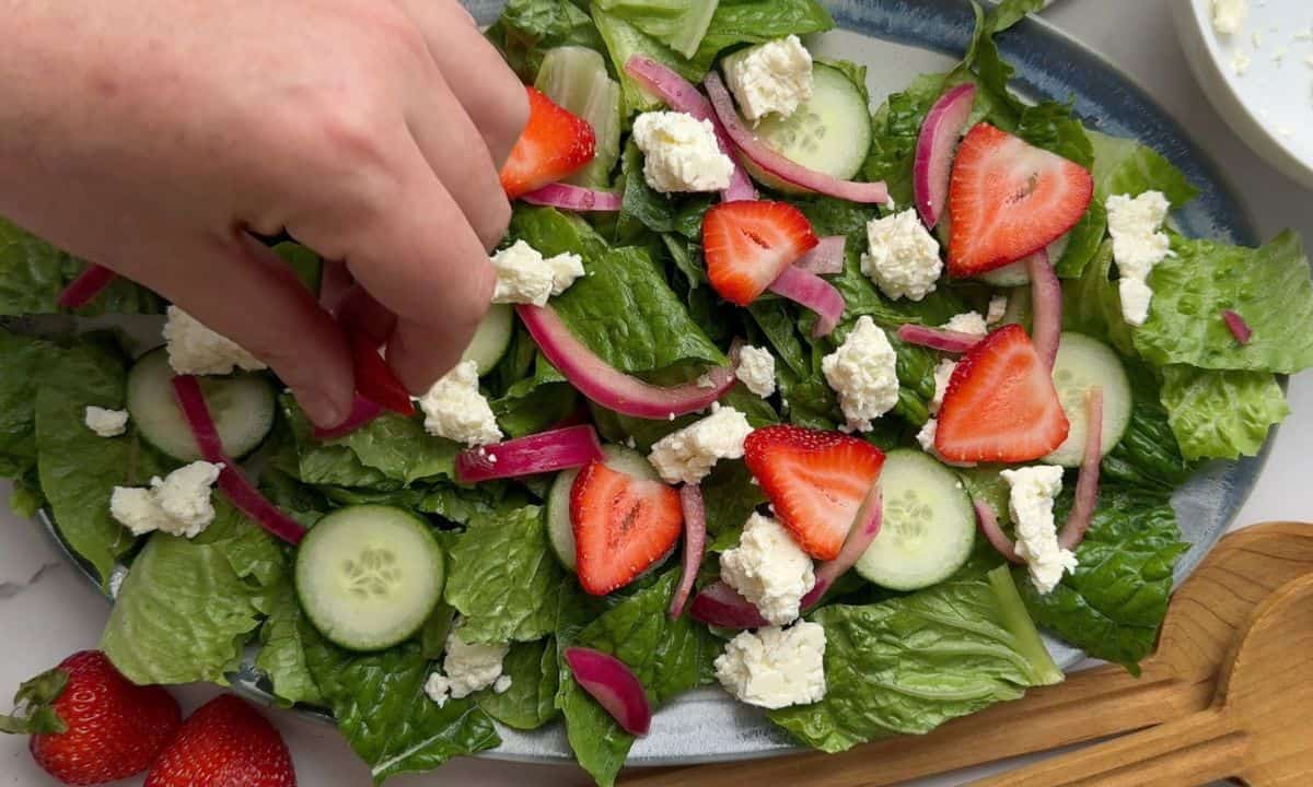 Placing the topped onto the salad.
